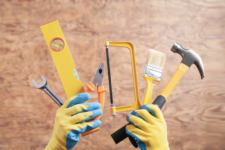 worker holding hammer saw brush level wrench pliers working tools 220873 6684